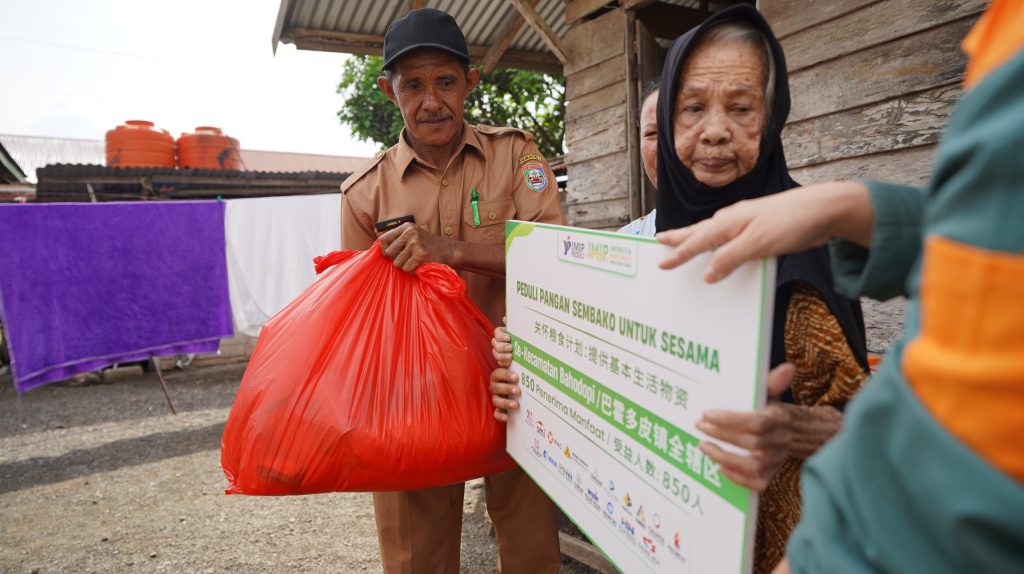 Ketgam : Perwakilan PT IMIP saat menyerahkan paket sembako kepada penerima bantuan