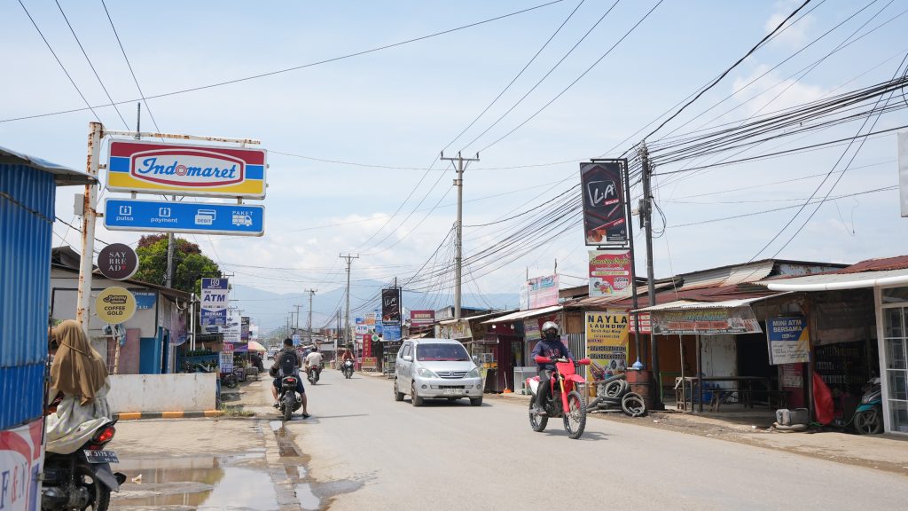 Deretan toko ritel bersisian dengan kios lokal, penatu (laundry), dan warung kelontong milik warga di sepanjang jalan utama di Kecamatan Bahodopi, Kabupaten Morowali, Sulawesi Tengah.
‎(Kredit foto: Departemen Media PT IMIP)